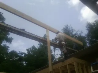 Carpenter setting a ridge beam over a new addition frame — Ice Dam Removal by Roofing Brothers in Larchmont