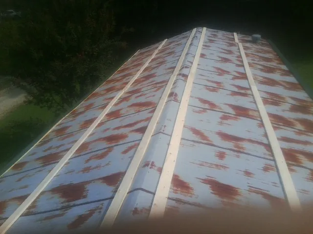 Rusted metal roof panels with new wood purlins before replacement — Storm Damage Roof Repair in Larchmont by Roofing Brothers