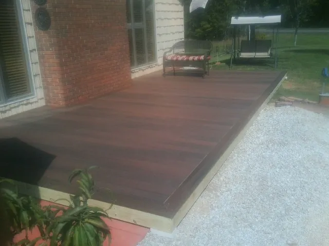 Freshly stained wood deck built against a brick home in Larchmont