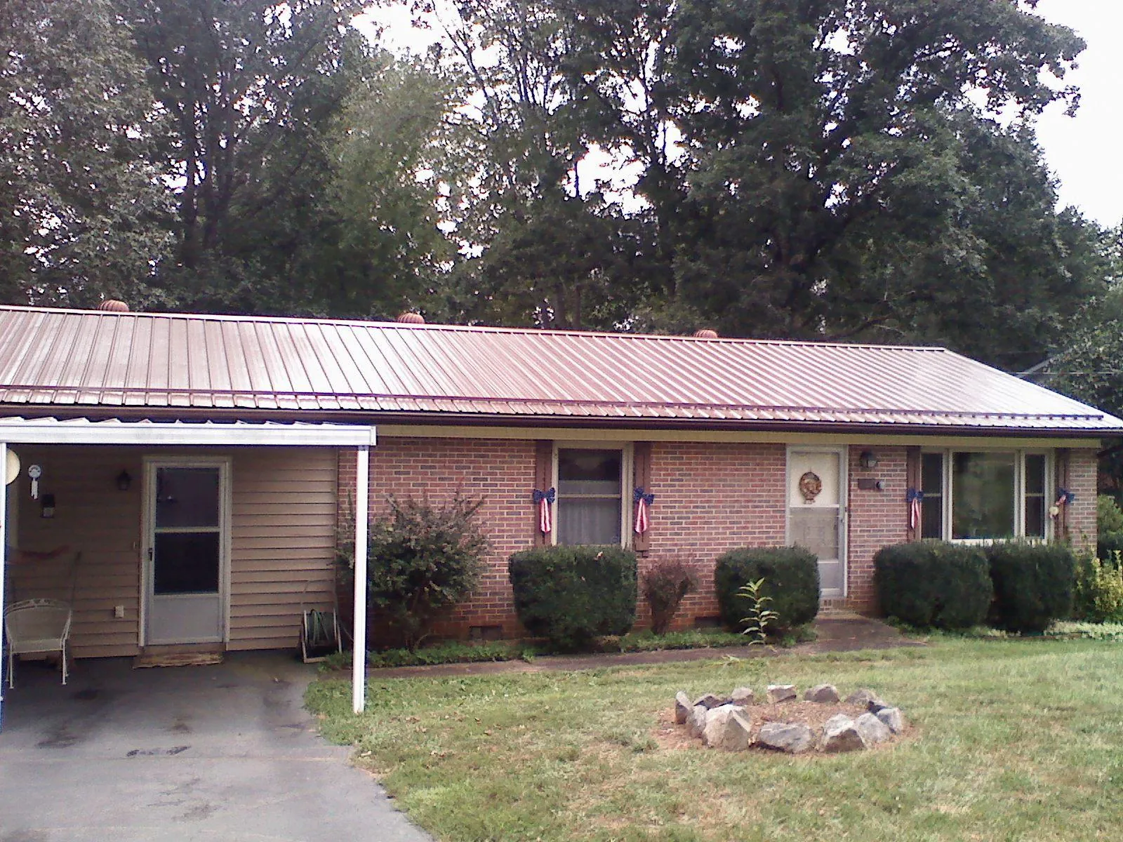 Bronze metal roof and carport on a brick ranch home — Roof Repair work by our crew in Larchmont
